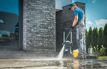 A man washing a stone terrace